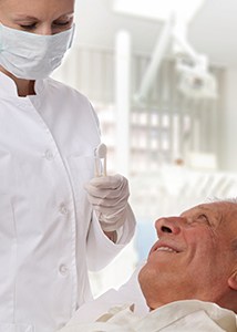 Older man smiling up at dentist
